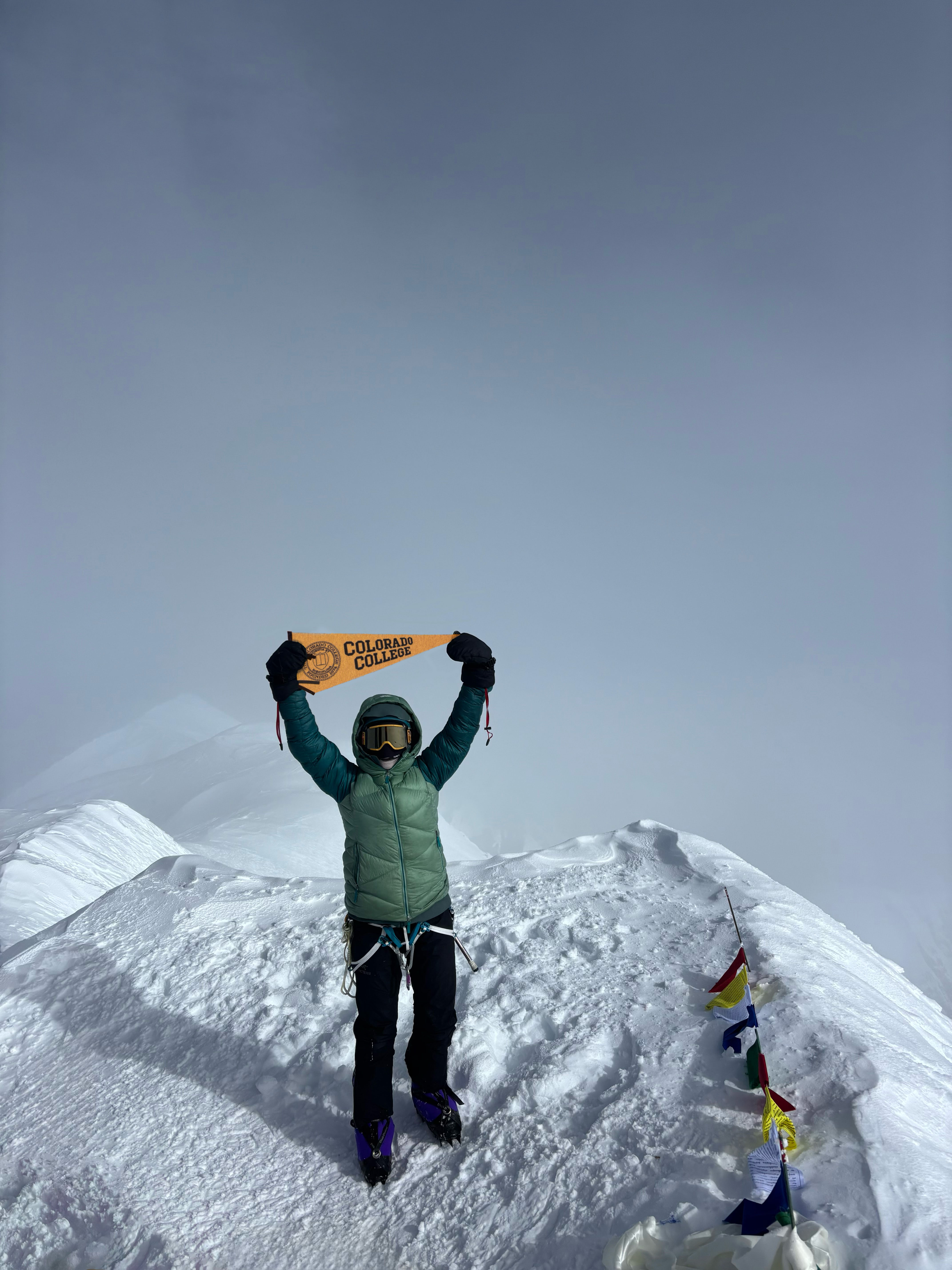 Mary Reinbold '25 shows her CC pride after reaching the top of Denali, the highest peak in North America, in Summer 2025. Photo provided by Reinbold.