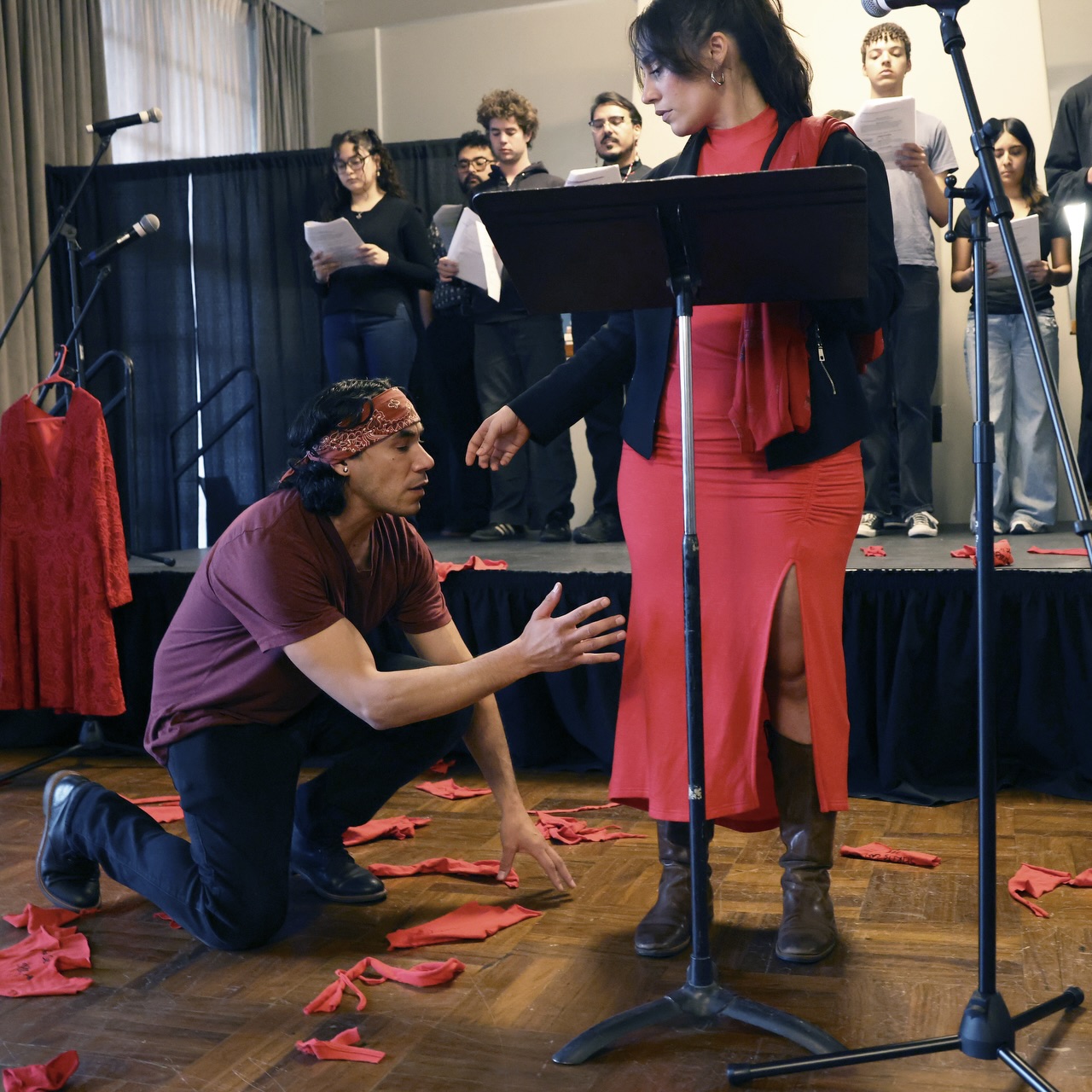 Ixtlan, a performer at the theatre reading for Missing and Murdered Indigenous Women and Relatives at the Fine Arts Center, kneels in interpretive dance beneath actor Angela Hernandez on May 5, 2026. Photo by Jamie Cotten / Colorado College