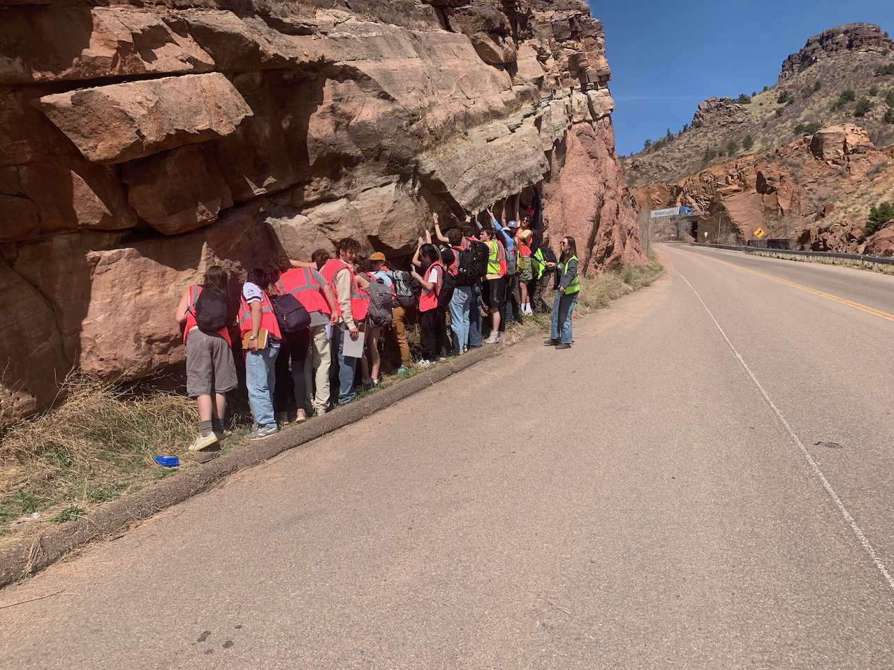Students in Block 7 2025 Introduction to Earth Systems are standing close to examine a very distinctive, important geological featured named The Great Unconformity. The location is on the west side of Manitou Springs, bordering Fountain Creek. Photo provided by class instructor and Geology Professor Christine Siddoway.